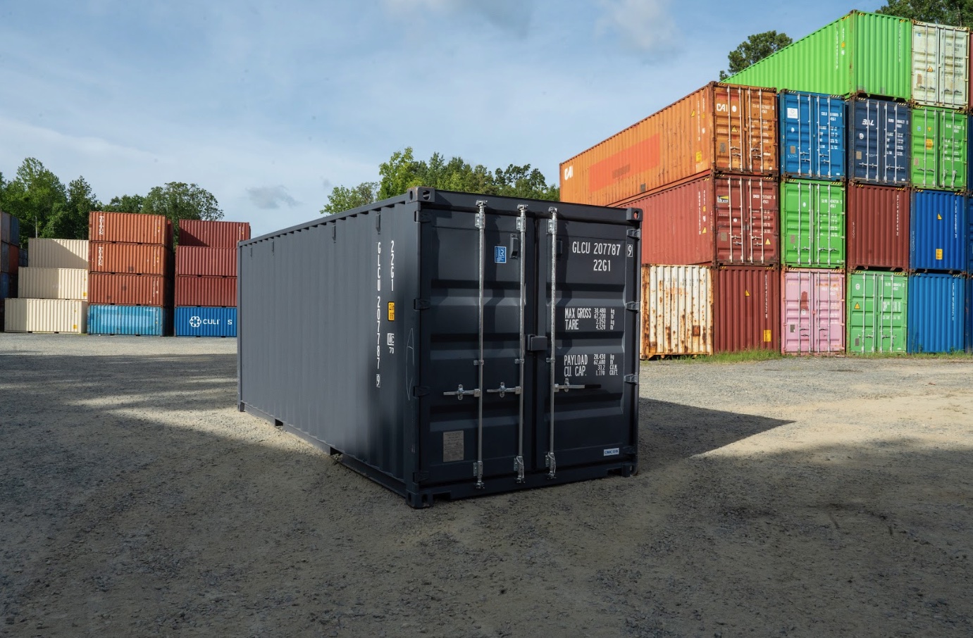 Black storage container with stacked shipping containers at the PVG yard in Locust, NC.